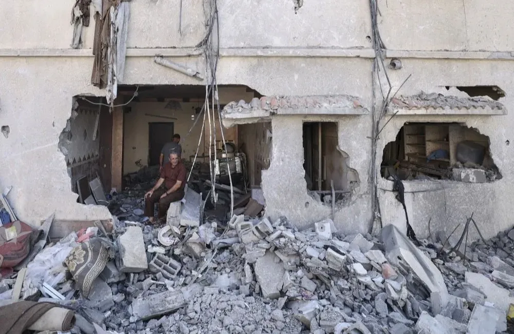 Un hombre se sienta en los escombros de su casa en la ciudad de Gaza; Israel abrió la frontera con la ciudad tras alcanzar una tregua