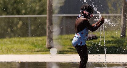Una niña juega en una fuente en Madrid Río, a 11 de julio de 2023, en Madrid (España)