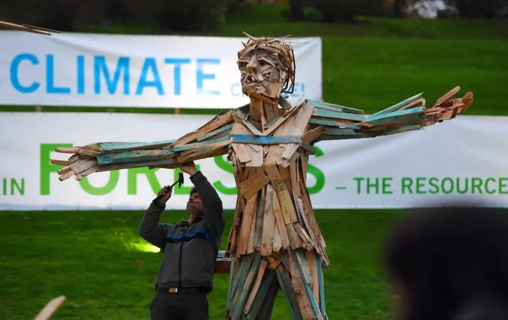 Una artista crea una figura armada de pedazos de madera como parte de una performance durante el evento de la COP23.