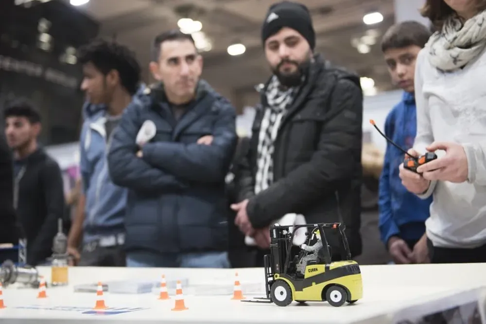 Migrantes asisten a la segunda edición de una feria de empleo para refugiados y migrantes en Alemania