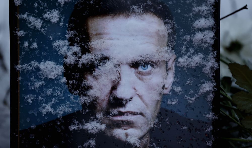 Los copos de nieve cubren parcialmente el retrato del fallecido líder opositor ruso Alexéi Navalni, marcando el primer aniversario de su muerte, frente a la Embajada de Rusia en Bucarest, Rumania.
