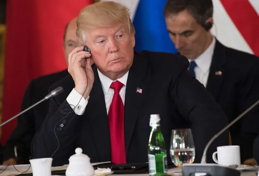 Donald Trump ajusta sus micrófonos durante el encuentro de los Tres Mares en el Castillo Real de Varsovia, hoy.