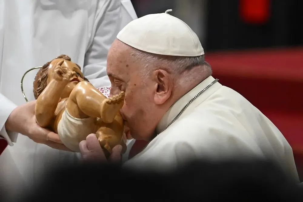El Papa Francisco besa una estatuilla del Niño Dios durante la misa de la Epifanía en la Basílica de San Pedro.