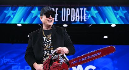 Elon Musk levanta una motosierra que le regaló el presidente de Argentina, Javier Milei, en la CPAC el 20 de febrero de 2025.
