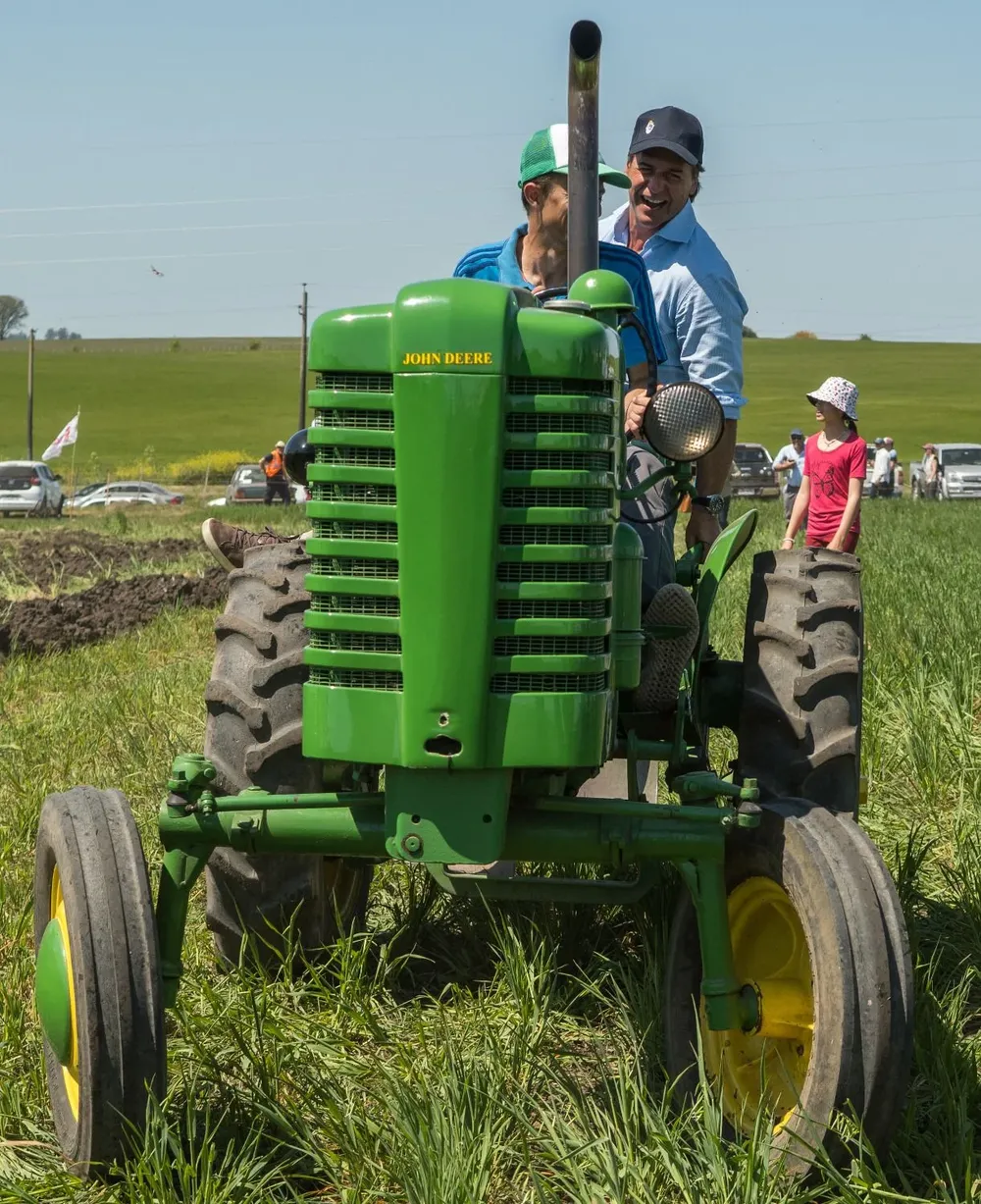 El presidente sobre el tractor viñatero, una de las piezas del Museo Roberto Fonte.