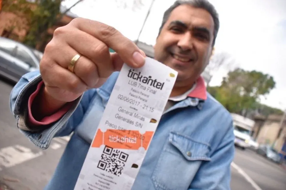 El hincha que muestra feliz la entrada