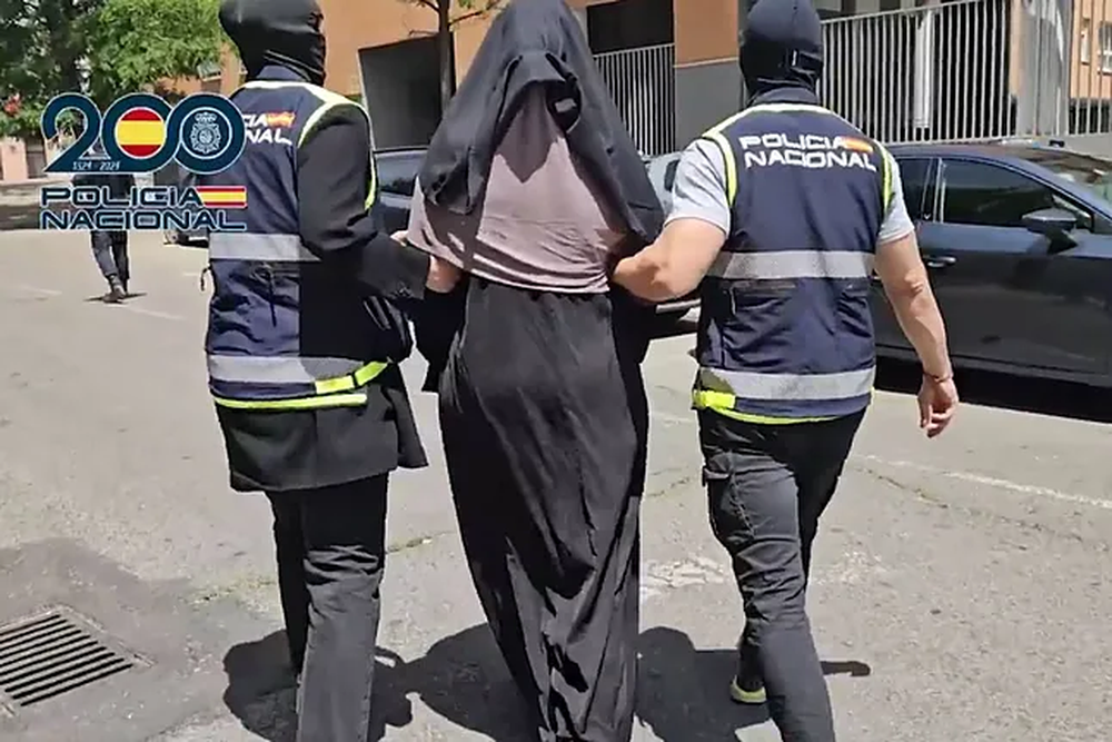 Una de las detenidas es escoltada por dos policías nacionales