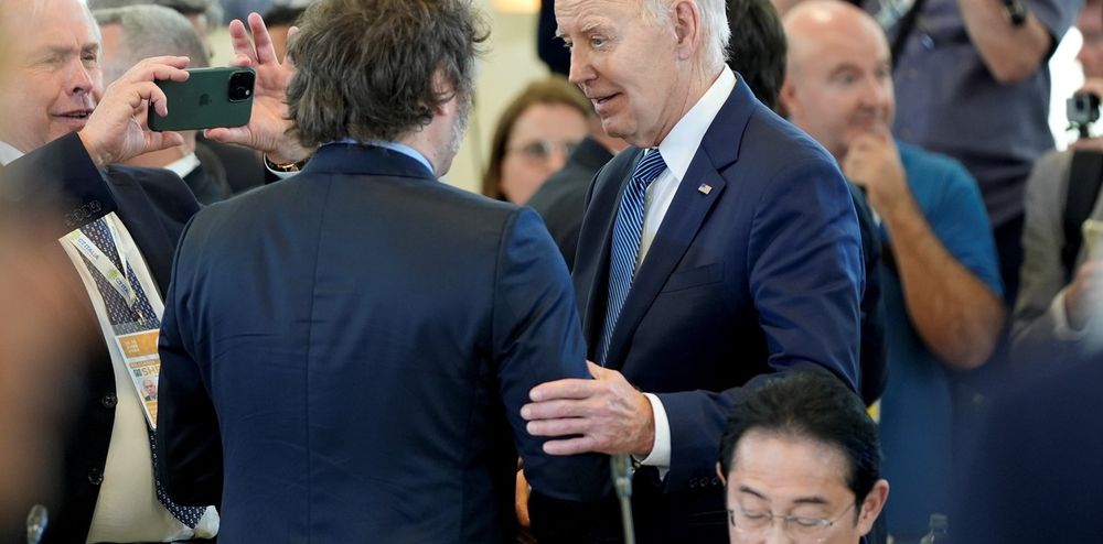 El presidente Javier Milei saluda a su par estadounidense Joe Biden&nbsp; mientras el embajador Gerardo Werthein los fotografía este viernes en el G7