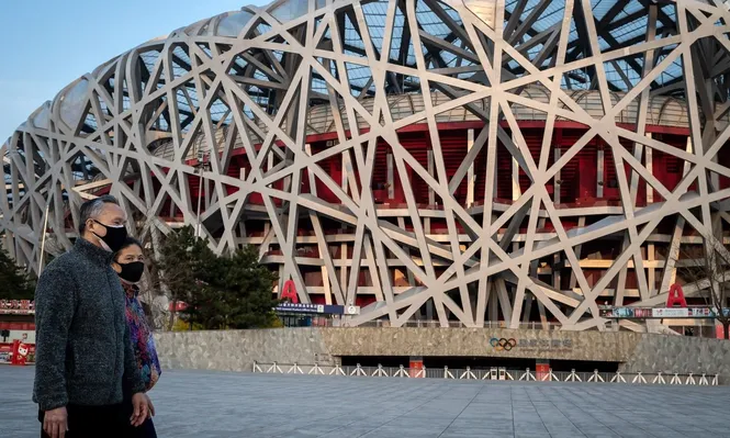 Ciudadanos chinos caminan cerca del estadio Nido de Pájaro