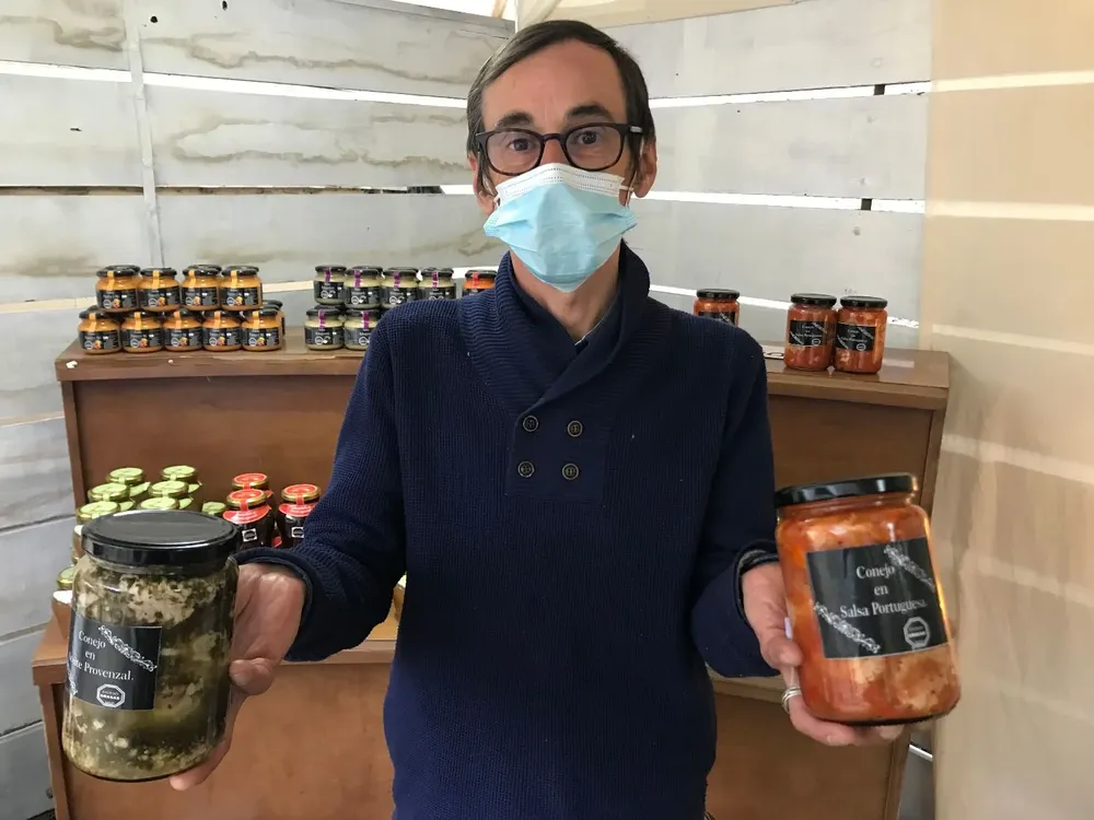 Alejandro Rodríguez y los frascos de elaboraciones que contienen carne de conejo.