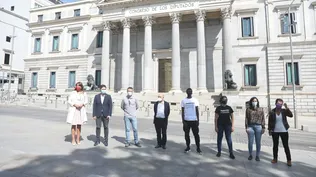 El trabajador migrante y miembro del movimiento #RegularizaciónYa Seydou Diop (4d); la portavoz de #RegularizaciónYa, Edith Espínola (3d); la diputada de Unidas Podemos Isabel Franco (2d); el portavoz de ERC en el Congreso de los Diputados, Gabriel Rufián (2i); y la portavoz de JxCat en el Congreso de los Diputados, Laura Borràs (1i); entre otros miembros del Congreso, posan frente al Congreso de los Diputados.