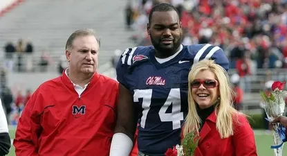 Michael Oher junto a sus padres de acogida
