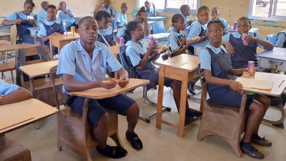 Aunque parece fuera de lugar en la clase de sexto grado, a Emmanuel Tuloe no le molesta la diferencia de edad.