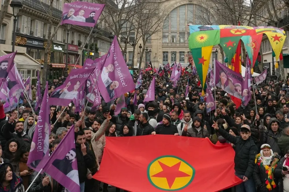 Los manifestantes llevaban banderas rojas del Partido de los Trabajadores del Kurdistán (PKK) y pancartas violetas con la imagen de las víctimas.