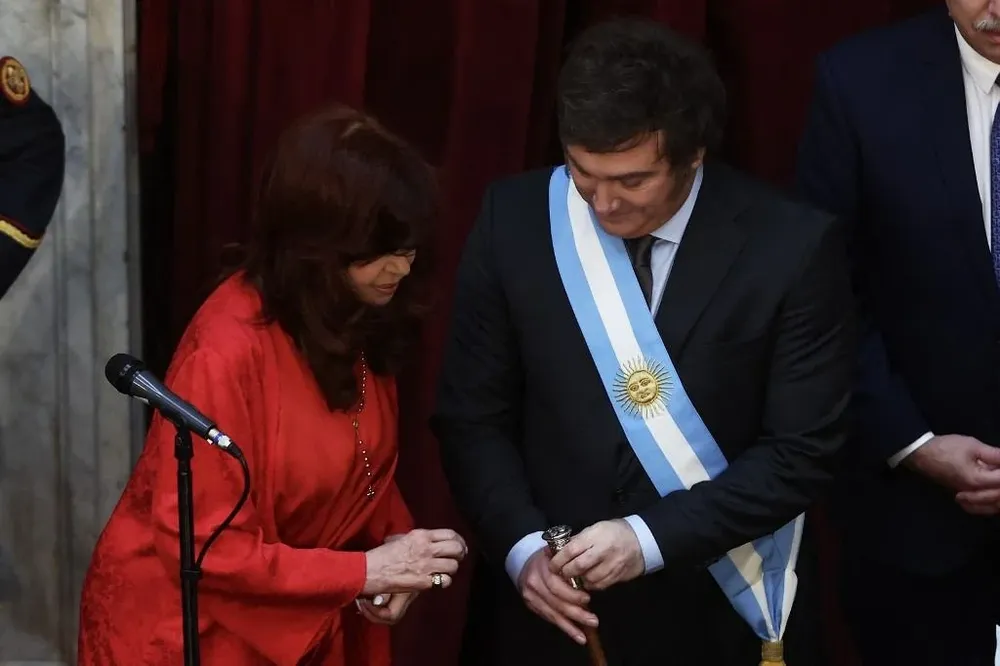 Momento en el que Milei muestra un detalle de su bastón presidencial a Cristina