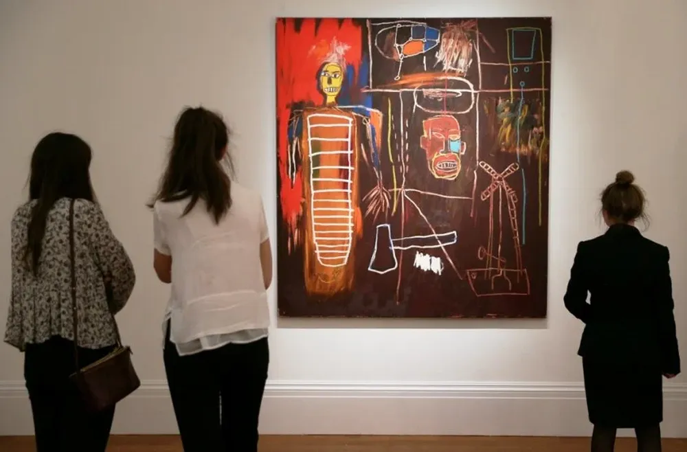 El público observando una de las obras de arte en exhibición que pertenecieron a David Bowie