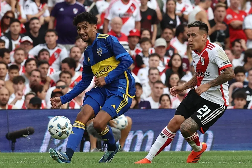 Cristian Medina, autor del gol del empate de Boca, disputa el balón con el mediocampista de River Esequiel Barco