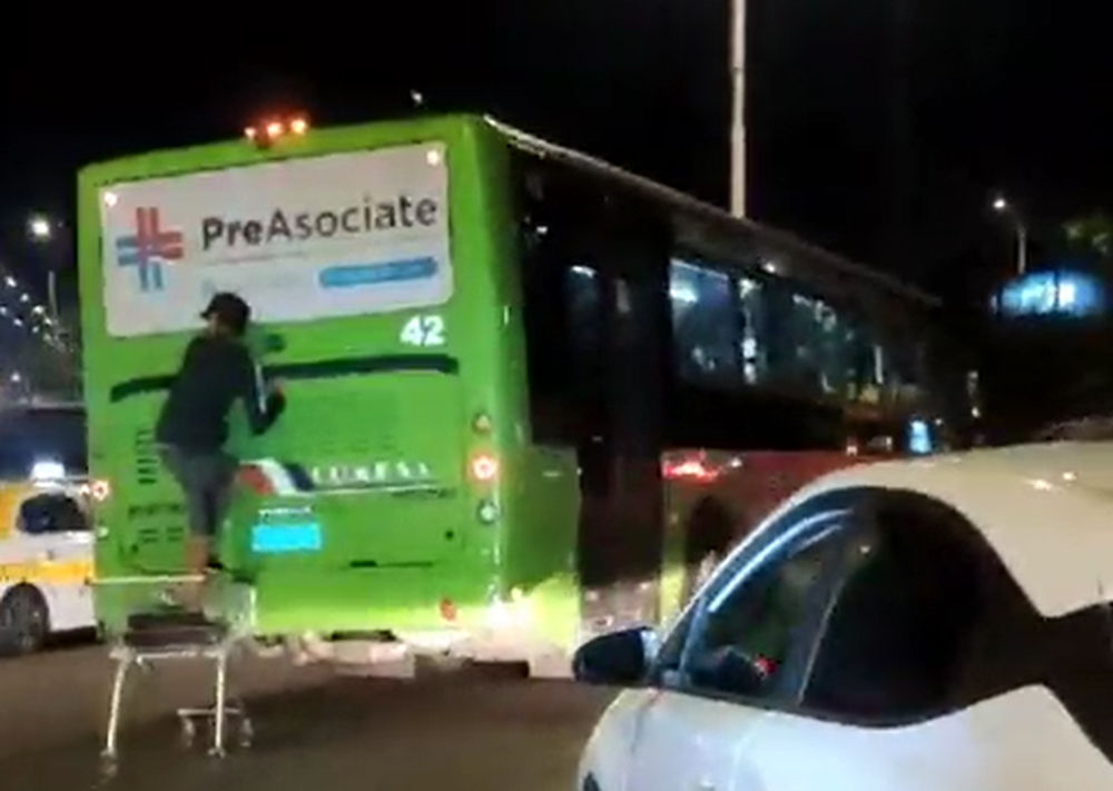 Persona colgada del ómnibus de Come S.A&nbsp;