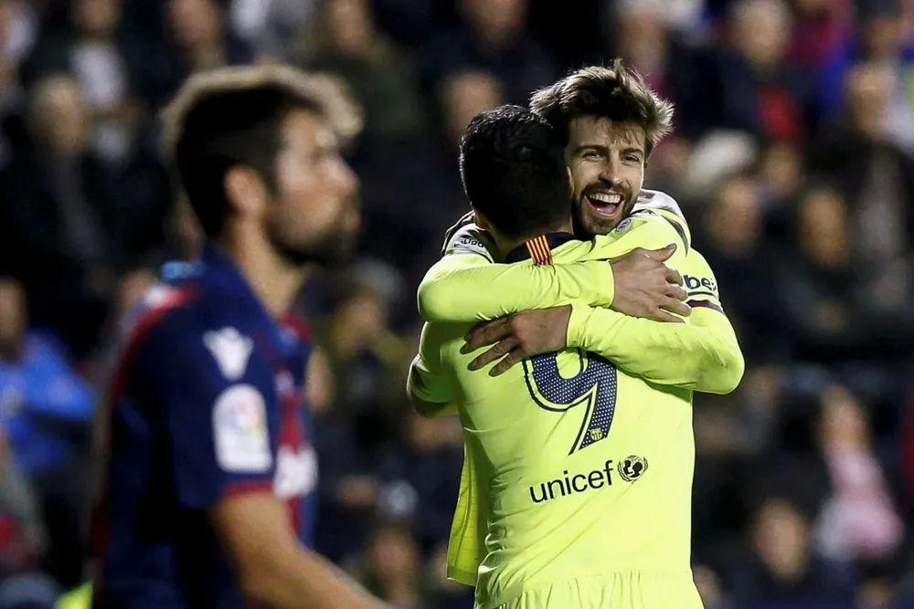 Gerard Piqué celebra con Luis Suárez tras marcar el quinto gol ante Levante