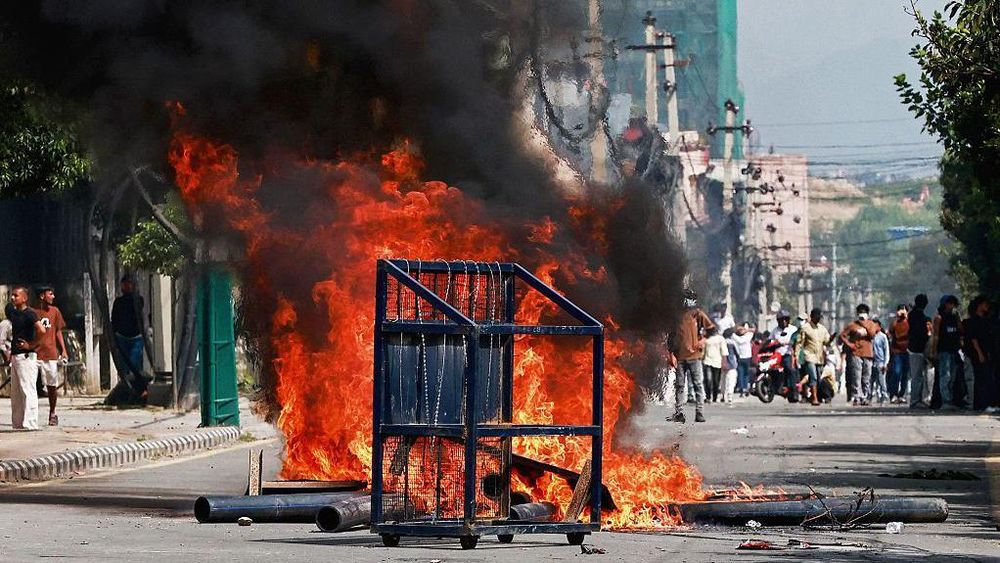 Una barricada policial frente a un incendio provocado por manifestantes durante una protesta frente al Parlamento en Katmandú.