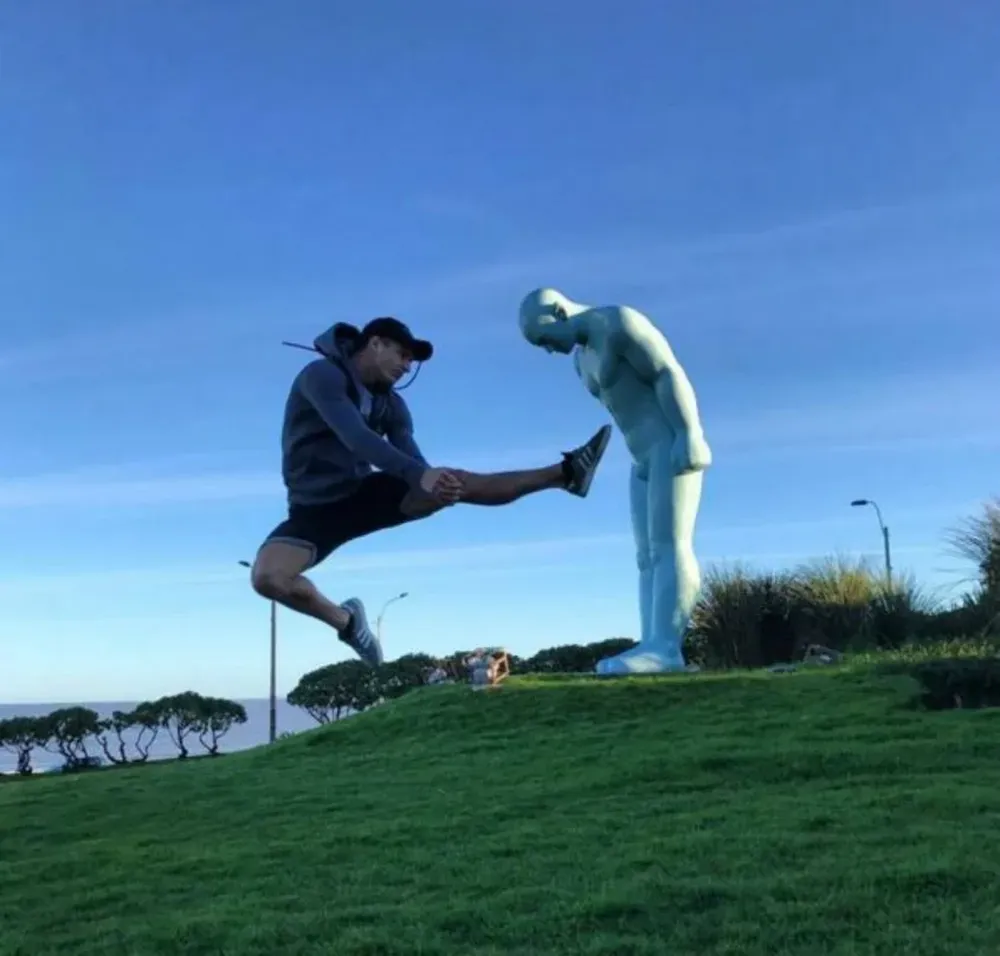 El artista británico David Rimmer, del Cirque du Soleil, frente al monumento Greetingman en la rambla de Montevideo