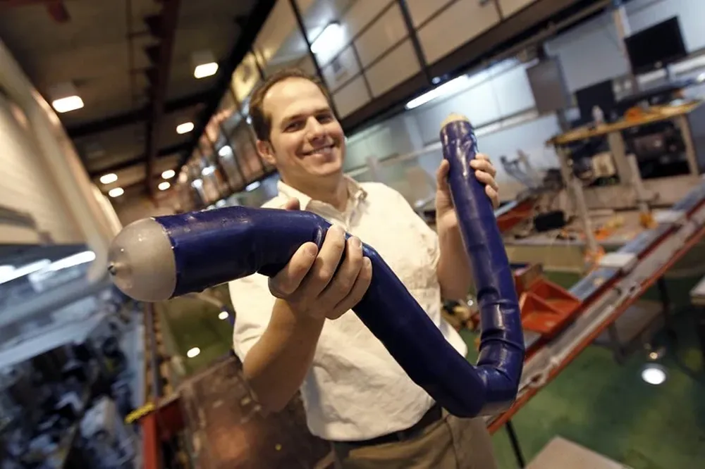 Brandon Taravella, profesor asistente de arquitectura naval e ingeniería marina, maneja un prototipo de anguila robótica en la Universidad de Nueva Orleans