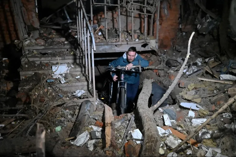 Un residente de Kharkiv sale de su casa en medio de los escombros luego del ataque ruso con drones de este domingo.