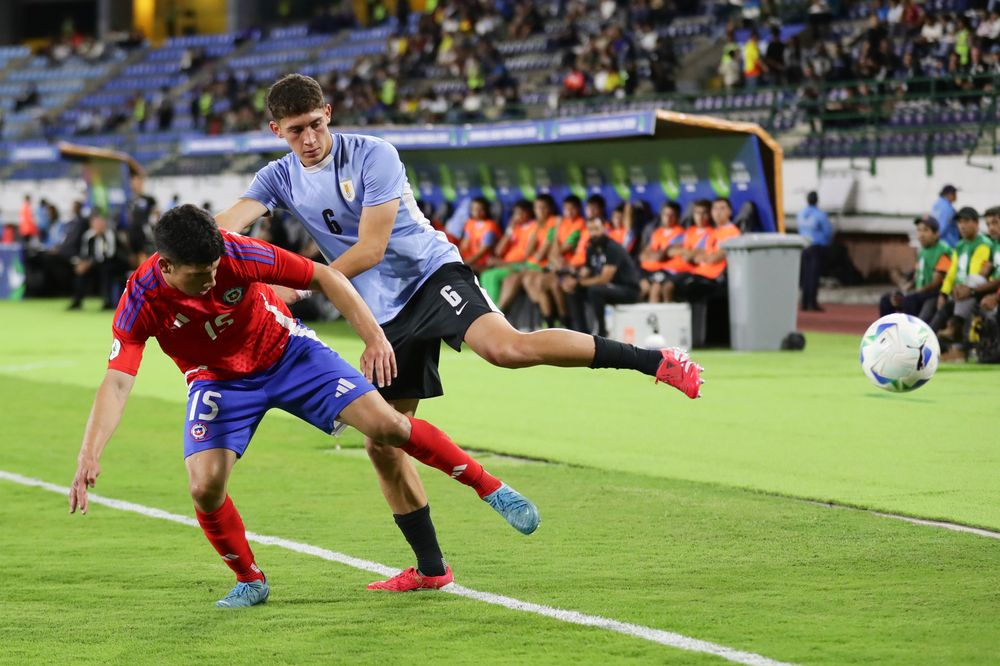 Nicolás Cárcamo de Chile disputa un balón con Patricio Pacífico de Uruguay
