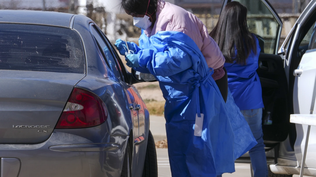 Personal de salud de Texas realiza un test de sarampión a un pasajero del auto.