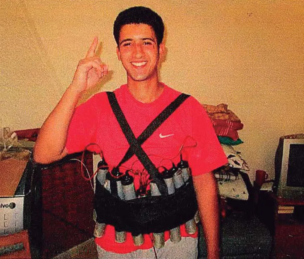 Youssef Aallaa posa para la fotografía con un chaleco de explosivos.