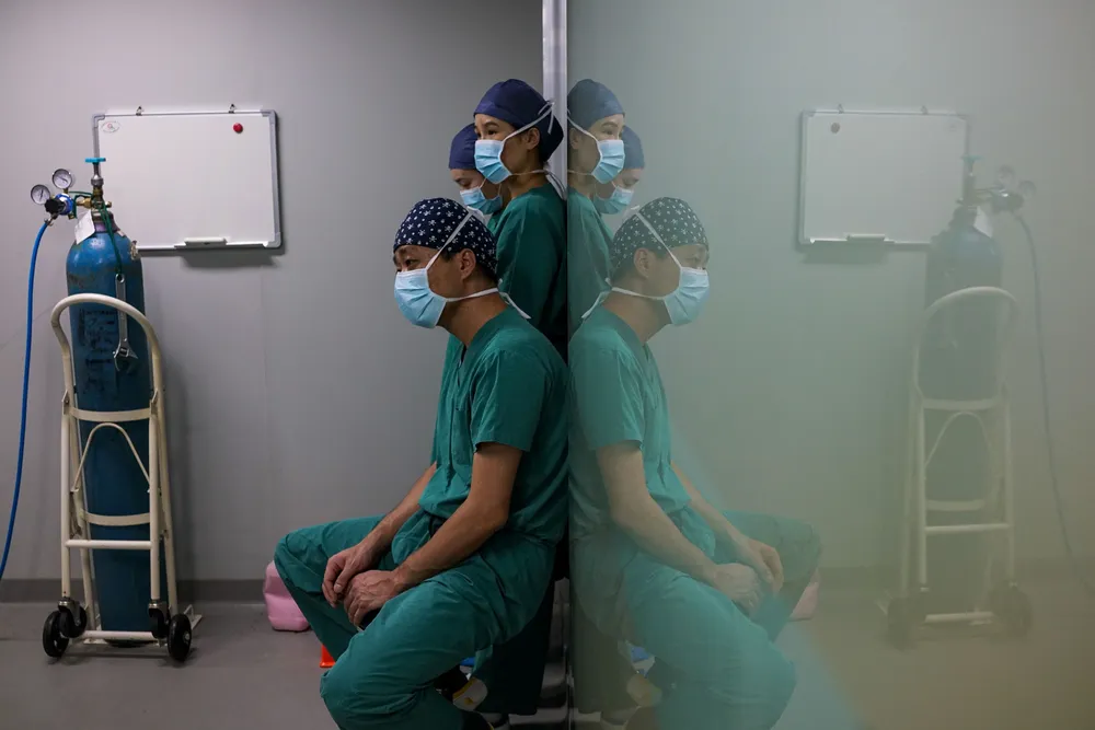In this photograph taken on August 22, 2017, surgeon Li Jian (front) sits before operating on a patient at Huamei Medical Cosmetology Hospital in Shanghai. Plastic surgery is booming in China, fuelled by rising incomes, growing Western influences and the imperative of looking good on social media. - To go with AFP story China-Lifestyle-Health-Social-Plastic, Feature by Peter Stebbings with Morgan Huang           / AFP / CHANDAN KHANNA / To go with AFP story China-Lifestyle-Health-Social-Plastic, Feature by Peter Stebbings with Morgan Huang