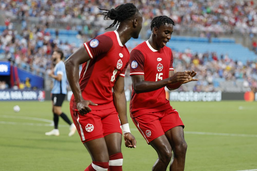 Ismael Koné y Bombito celebran uno de los goles de Canadá ante la selección de Uruguay