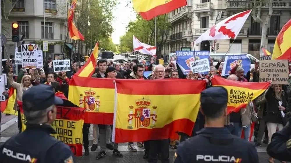 Asistentes a la manifestación para pedir la dimisión de Pedro Sánchez, este jueves en la calle de la sede del PSOE
