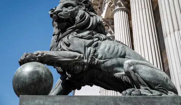 Uno de los emblemáticos leones que se encuentran delante de la fachada del Congreso de los Diputados en la Plaza de las Cortes de Madrid.(Archivo)