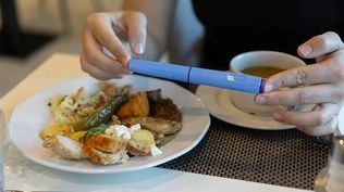 Una mujer con una dosis de Ozempic junto a un plato de comida y una taza de sopa.