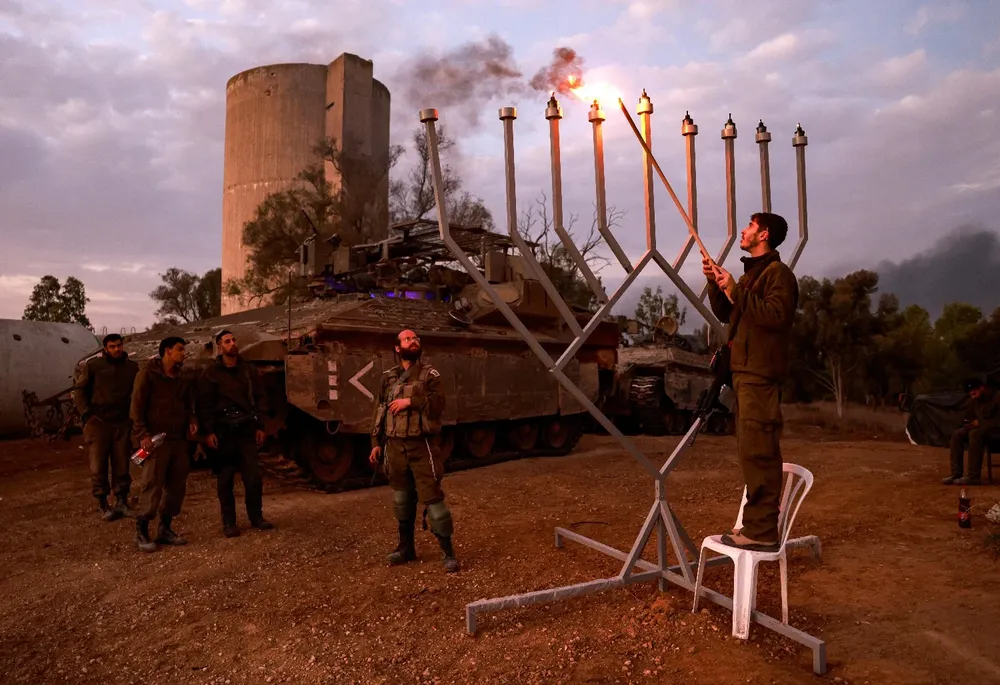 Soldados israelíes en Gaza encienden un gigantesco candelabro por la festividad judía de Janucá.