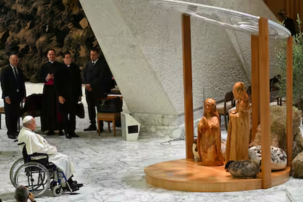 El Papa Francisco reza frente al Belén donde el niño Jesús está envuelto en un tradicional pañuelo palestino