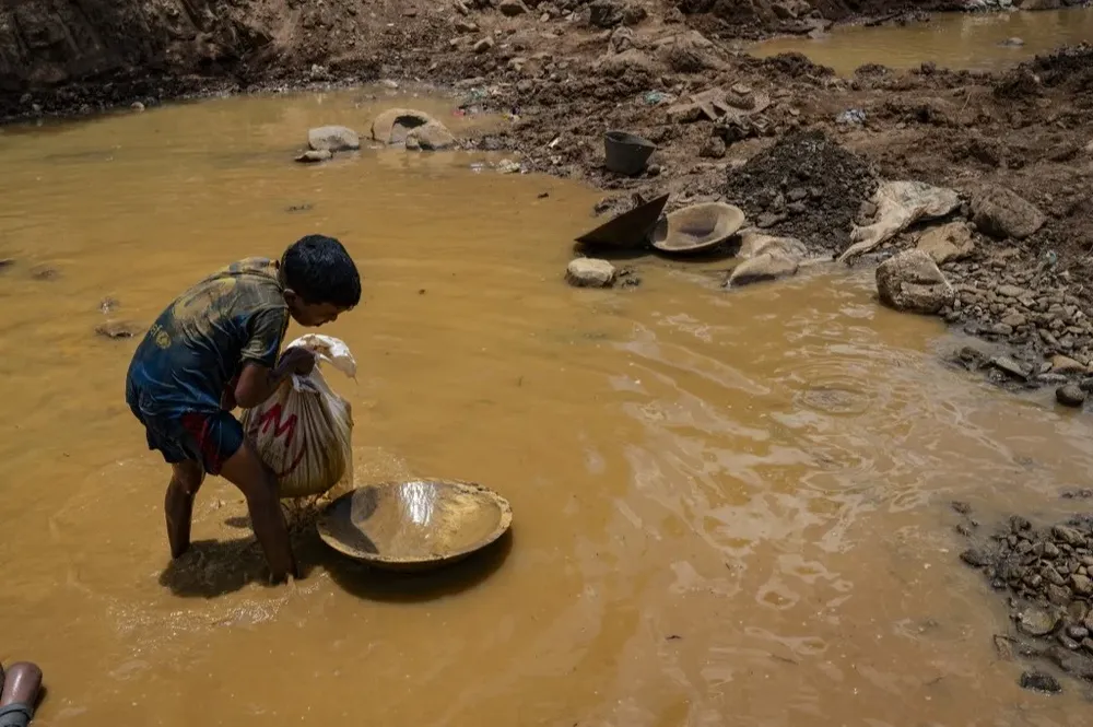 Sentados en charcos de lodo, los chicos mueven bandejas entre piedras, vidrio y hasta basura en busca de pepitas de oro que se adhieran al mercurio, contaminante y nocivo para la salud.