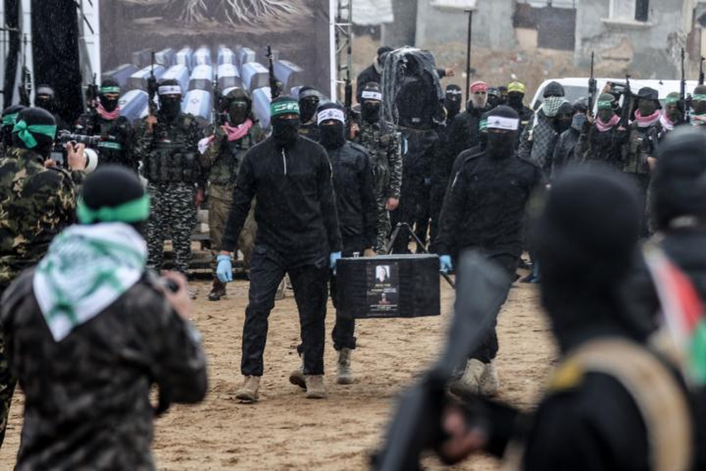 Militantes de Hamás entregan cadáveres de rehenes israelíes.