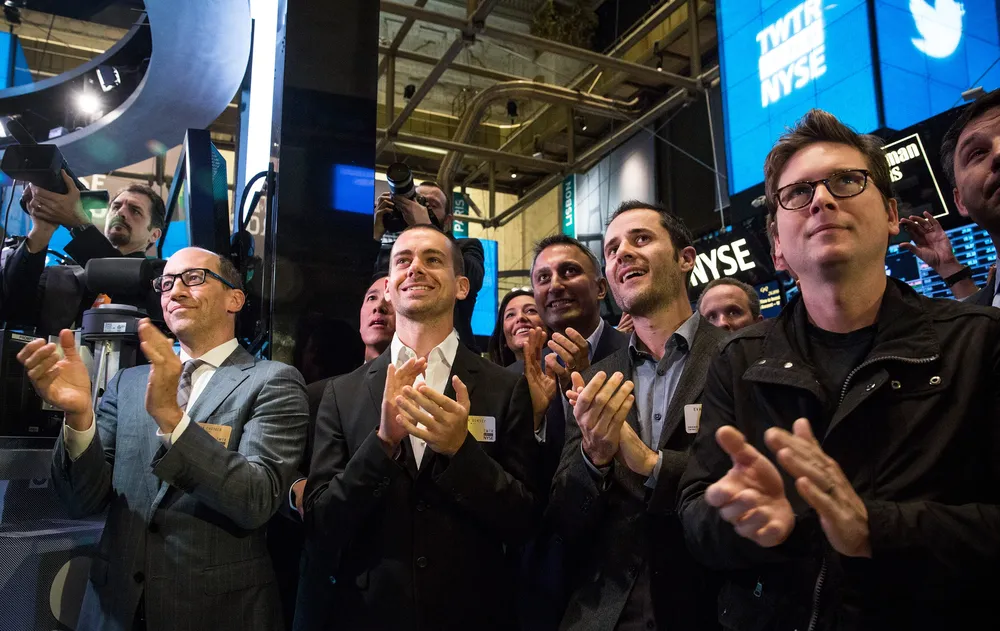 El CEO de Twitter, Dick Costolo, y los cofundadores Jack Dorsey, Evan Williams y Biz Stone, aplauden cuando suena la campana de Twitter en la bolsa de Nueva York