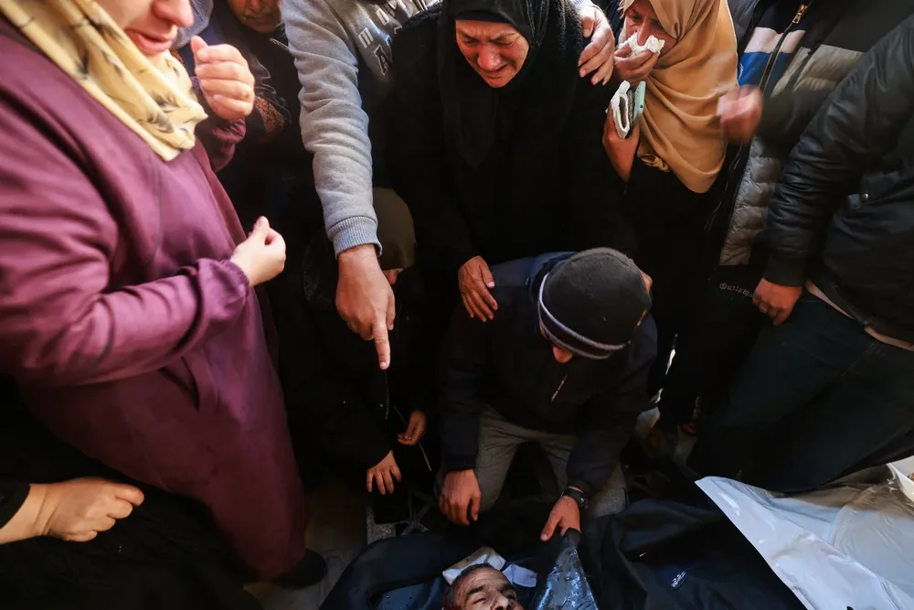 Familiares de las víctimas del bombardeo israelí contra un refugio de Naciones Unidas en el sur de la Franja de Gaza.