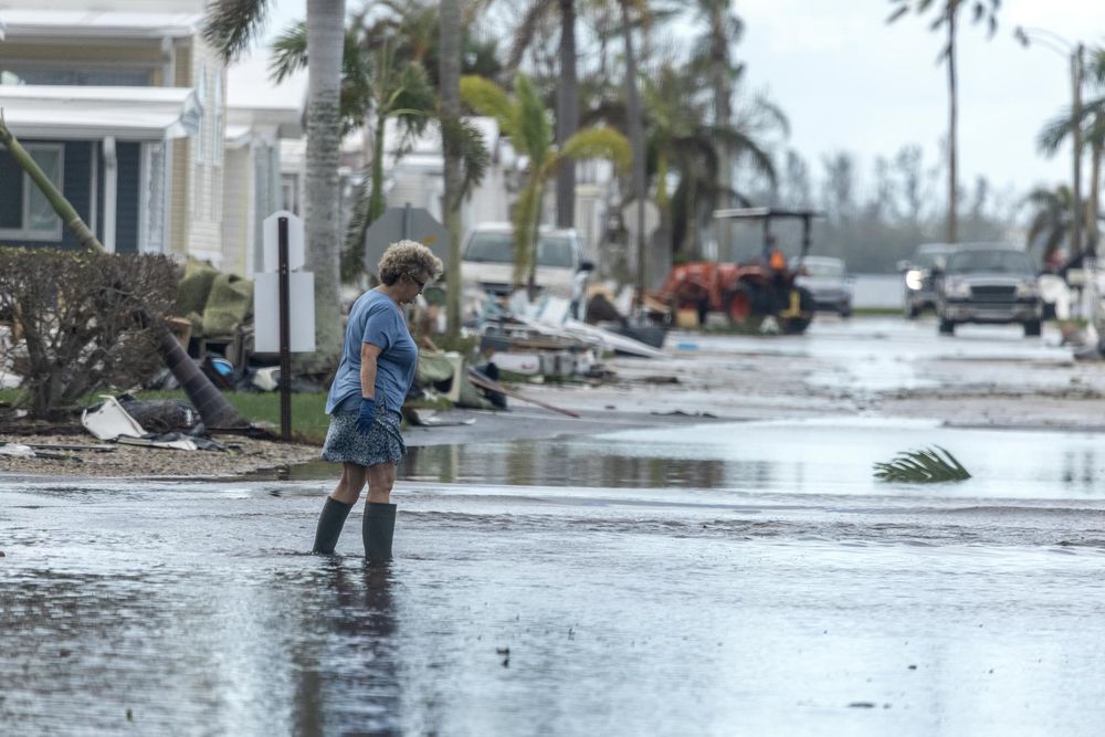 Una mujer camina por una calle inundada en Bradenton, Florida, tras el paso de Milton