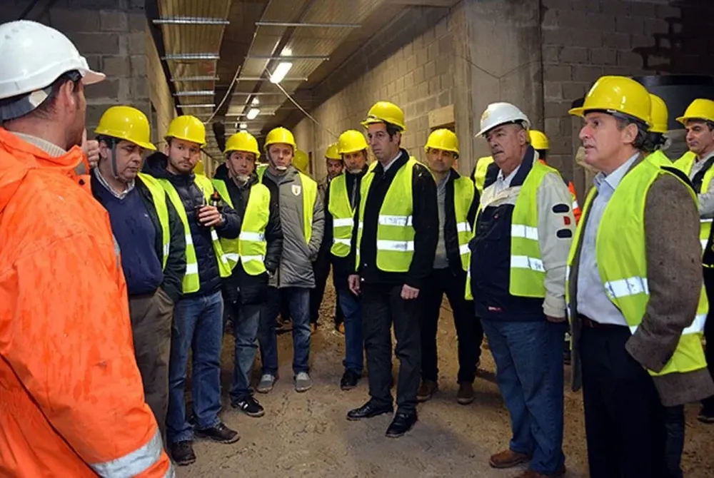 El Nono Giuria, de casco blanco, y toda la comitiva de la AUF escuchan cómo van las obras