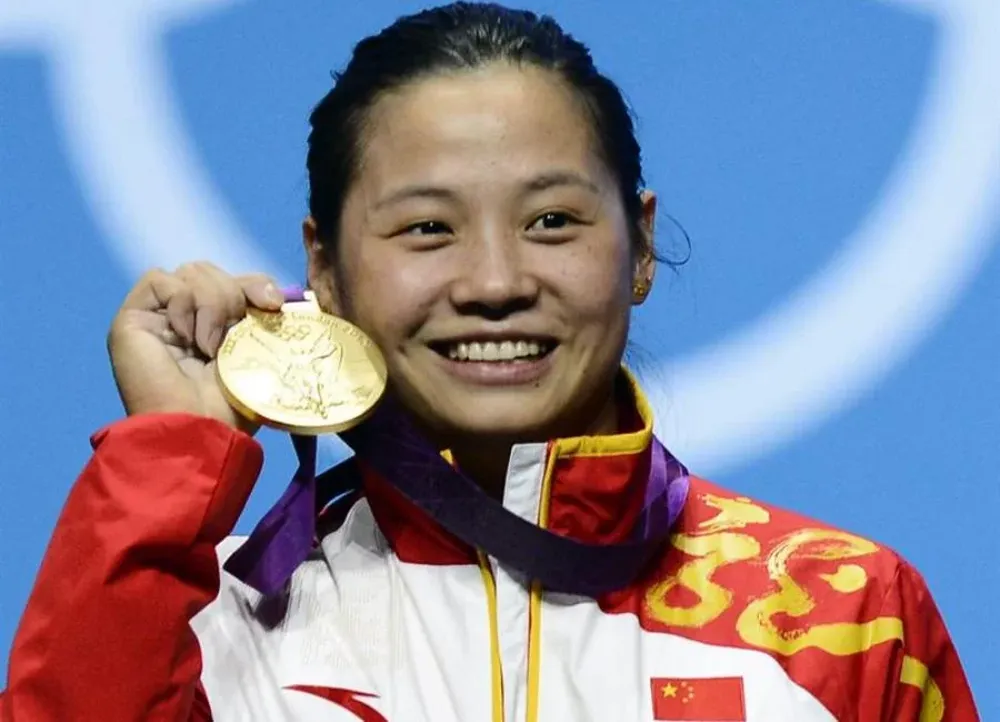 Li Xueying posa con el oro (levantamiento de pesas)