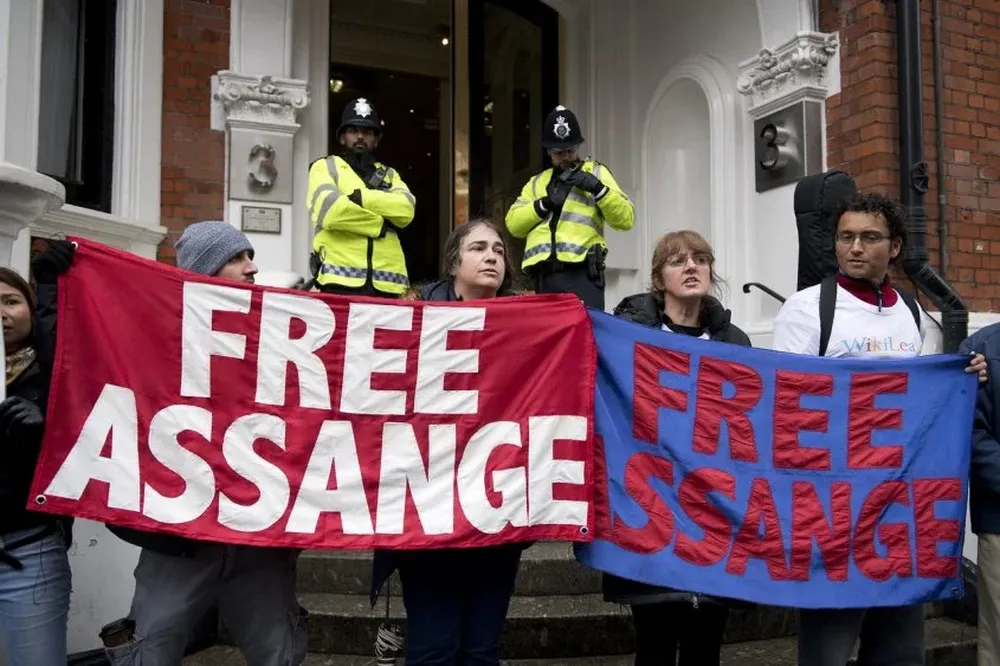 Manifestantes llevan carteles en donde se lee Liberen a Assange en la puerta de la embajada de Ecuador en Londres