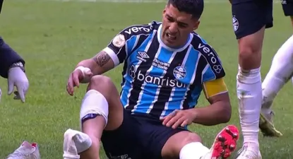 Luis Suárez en el piso y sin la media derecha por la plancha que recibió de André de Fluminense
