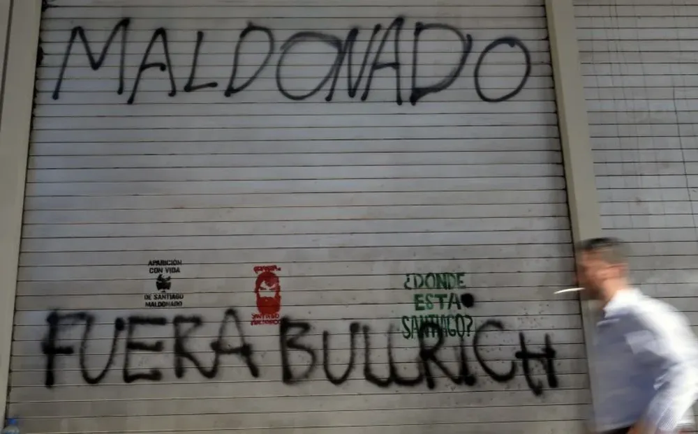 Un hombre pasa frente a un graffiti que exige conocer el paradero de Santiago Maldonado en Argentina 