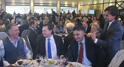 Luis Lacalle Pou (derecha), conversa con Yamandú Orsi (izquierda), con Rodrigo Ferrés e Isaac Alfie en medio, en el Día del Exportador