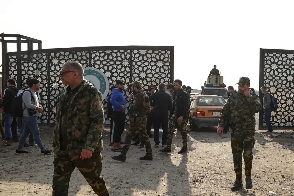 Miembros del Hashed al-Shaabi iraquí se reúnen a la entrada de su cuartel general en Bagdad al recibir la noticia de la muerte de Al Saidi.