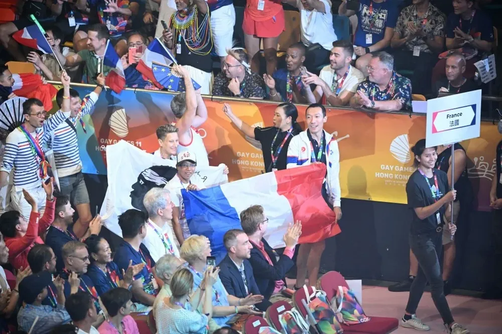 Los atletas, vestidos con vivos colores, entraron al estadio Queen Elizabeth blandiendo sus banderas nacionales y arcoíris.